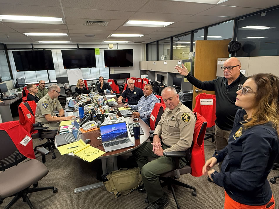Asm. Addis speaking with emergency agency representatives seated at table