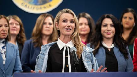 First Partner Jennifer Siebel Newsom at podium, speaking, with legislators standing in support