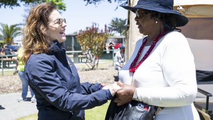Asm. Addis holding hands and speaking with constituent