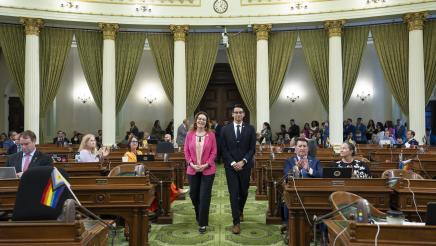 Asm. Addis walking Fellow Michael Guerra down the aisle on the Assembly Floor