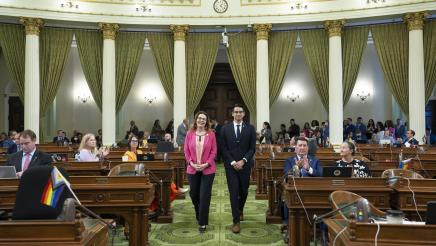 Asm. Addis walking Fellow Michael Guerra down the aisle on the Assembly Floor