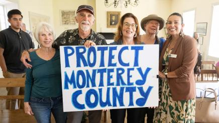 Asm. Addis and attendees holding up 'Protect Monterey County' sign