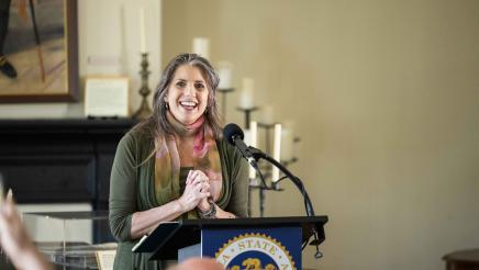 Guest speaker at podium at head of room, speaking
